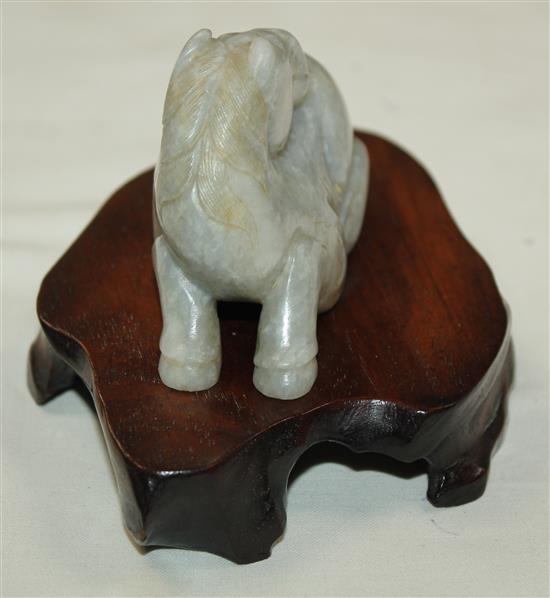 A Chinese mottled pale grey jade figure of a recumbent horse, probably Ming dynasty, 7.2cm, wood stand